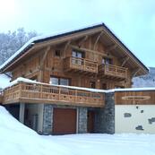 Chalet Les Sauges' exterior with a fresh sprinkling of snow